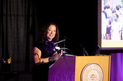 Woman standing and smiling at podium 